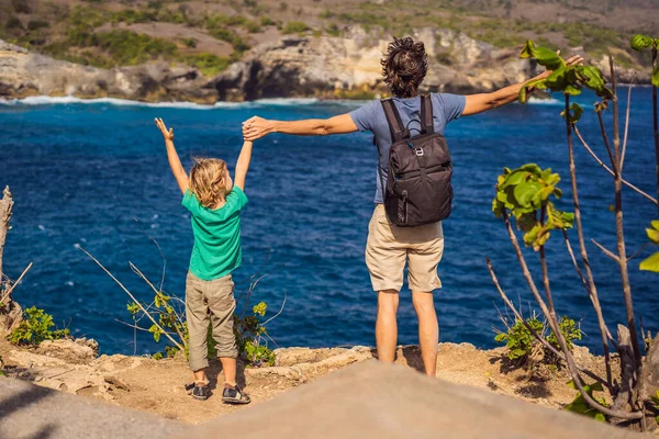 Papa en zoon toeristen tegen de achtergrond van de zee Engelen Billabong in Nusa Penida, Bali, Indonesië. Reis naar Bali met kids concept — Stockfoto