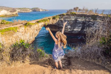 Endonezya Angels Billabong Plajı 'ndaki Nusa Penida' daki Broken Beach yakınlarında genç bir kadın turist. Popüler turizm beldesi Bali