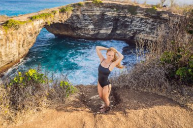 Endonezya Angels Billabong Plajı 'ndaki Nusa Penida' daki Broken Beach yakınlarında genç bir kadın turist. Popüler turizm beldesi Bali