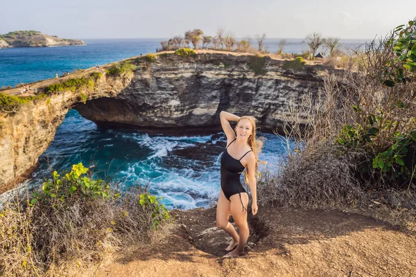 Turista joven cerca de Broken Beach en Nusa Penida, Indonesia Angels BillaBong Beach. Destino turístico popular Bali —  Fotos de Stock