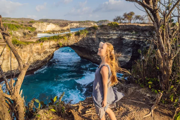 Mladá žena turista poblíž Broken Beach v Nusa Penida, Indonésie Angels Billabong Beach. Oblíbená turistická destinace Bali — Stock fotografie