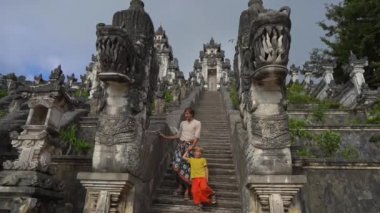 Endonezya 'nın Bali adasındaki Pura Lempuyang Tapınağını ziyaret eden baba ve oğlunun yavaş çekimleri.