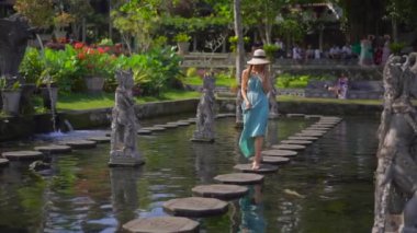 Endonezya 'nın Bali Adası' ndaki eski kraliyet sarayı Tirta Gangga su sarayını ziyaret eden genç bir turistin yavaş çekimleri.