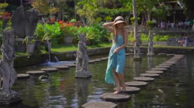 Endonezya 'nın Bali Adası' ndaki eski kraliyet sarayı Tirta Gangga su sarayını ziyaret eden genç bir turistin yavaş çekimleri.