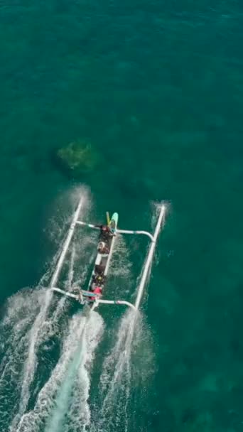 Vidéo verticale. Vue aérienne d'un bateau de pêche qui amène des plongeurs aux spots de plongée sur une île tropicale — Video