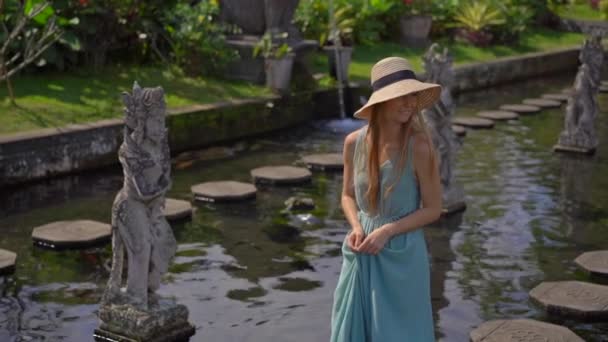 Zeitlupenaufnahme einer jungen Touristin beim Besuch des Wasserpalastes Tirta Gangga, des ehemaligen königlichen Palastes auf der Insel Bali, Indonesien — Stockvideo