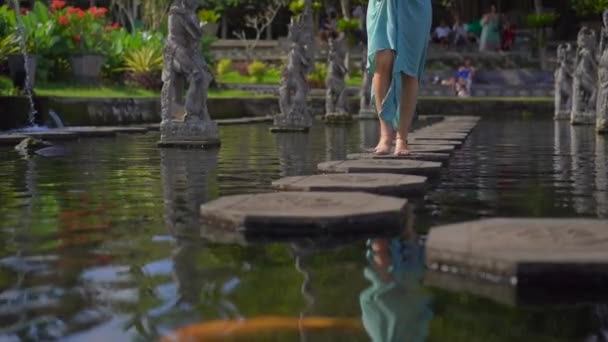 Langzame opname van een jonge toerist op bezoek bij het waterpaleis Tirta Gangga, voormalig koninklijk paleis op Bali, Indonesië — Stockvideo