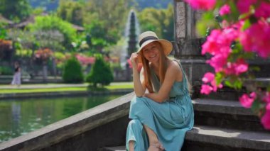 Endonezya 'nın Bali Adası' ndaki eski kraliyet sarayı Tirta Gangga su sarayını ziyaret eden genç bir kadın turist.