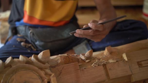 Медленный крупный план мастера, делающего традиционную резьбу по дереву — стоковое видео