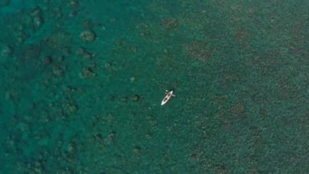 Mercanlarla dolu bir denizde kano üzerinde bir çiftin havadan çekilmiş görüntüleri. — Stok video