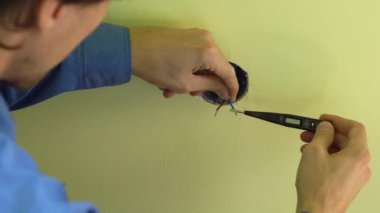 Soket yüklemeyi yapan genç profesyonel elektrikçi closeup çekim.