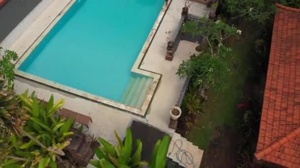 Luchtfoto van een jonge vrouw en haar zoontje toeristen die zich vermaken in een zwembad in een tropische omgeving. Begrip tropisch leven — Stockvideo