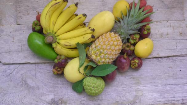Top of view - kezét egy nő tartja a szív készült sok trópusi gyümölcs — Stock videók
