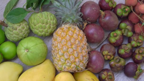 Tahta arka planda bir sürü tropikal meyve var. — Stok video