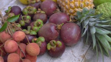 Tahta arka planda bir sürü tropikal meyve var.