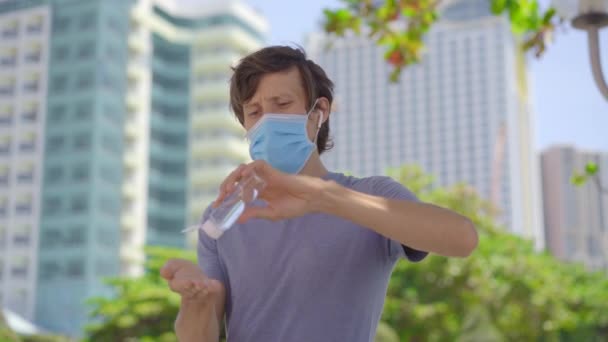 COVID-19 Coronavírus pandémico. Um homem usando um gel higienizador de mão, contra o novo coronavírus 2019-nCoV ou COVID 19 na rua da cidade. Antisséptico, Higiene e Cuidados de Saúde — Vídeo de Stock