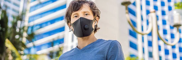 Fashionable black medical mask with filter in the city. Coronavirus 2019-ncov epidemic concept. Man in a black medical mask. Portrait of a man with expressive eyes during a virus or disease epidemic — Stock Photo, Image