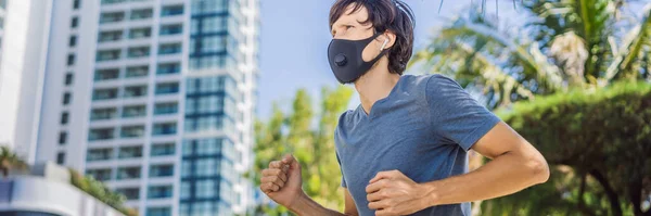 BANNER, LONG FORMAT Man runner wearing medical mask. Running in the city against the backdrop of the city. Coronavirus pandemic Covid-19. Sport, Active life in quarantine surgical sterilizing face — Stock Photo, Image