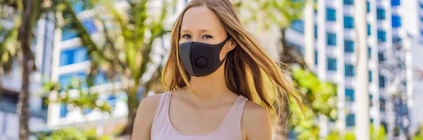 Modische schwarze medizinische Maske mit Filter in der Stadt. Coronavirus 2019-ncov epidemic concept. Frau in schwarzer medizinischer Maske. Porträt einer Frau mit ausdrucksstarken Augen während eines Virus oder einer Krankheit — Stockfoto