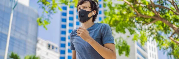 BANNER, LANG FORMAT Man loper met medisch masker. Rennend in de stad tegen de achtergrond van de stad. Coronavirus pandemie Covid-19. Sport, Actief leven in quarantaine chirurgische sterilisatie gezicht — Stockfoto