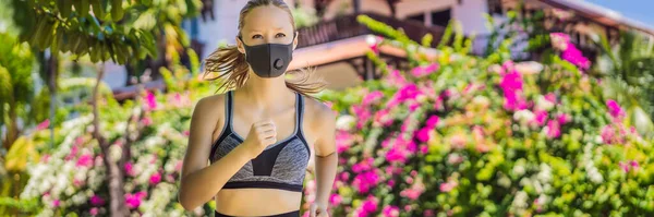 BANNER, LONG FORMAT Woman runner wearing medical mask. Running in the park. Coronavirus pandemic Covid-19. Sport, Active life in quarantine surgical sterilizing face mask protection. Outdoor run on