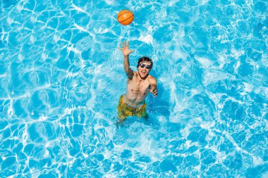 Adam plaj topuyla havuzda oynuyor.