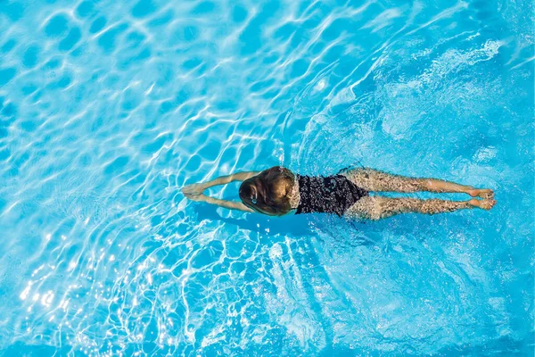 Femme en lunettes de soleil nage dans la piscine — Photo