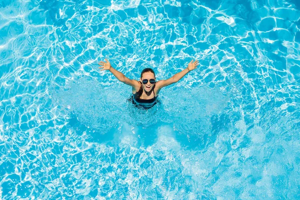 Mulher de óculos de sol nada na piscina — Fotografia de Stock