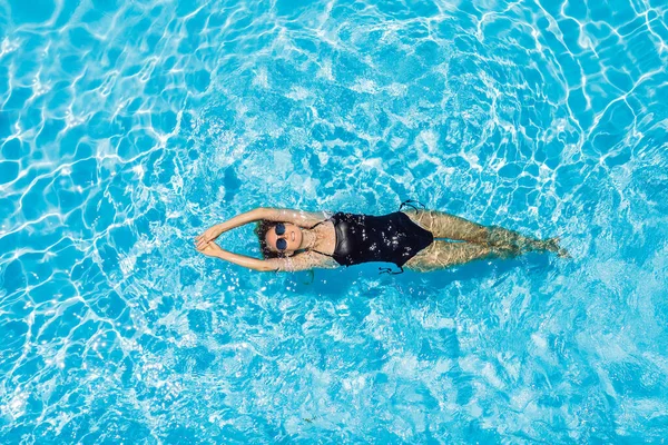 Γυναίκα με γυαλιά ηλίου κολυμπάει στην πισίνα — Φωτογραφία Αρχείου