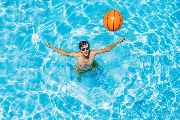 Adam plaj topuyla havuzda oynuyor.