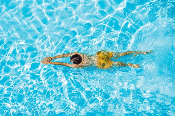 Hombre joven nada en la piscina, concepto de vacaciones de verano —  Fotos de Stock