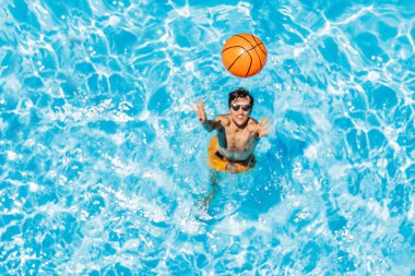 Adam plaj topuyla havuzda oynuyor.