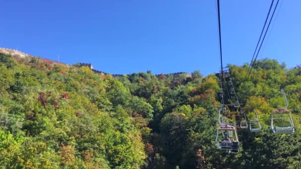 Atingido por um telefone. Elevador de cabo para o topo da colina onde a Grande Muralha Chinesa está localizada. Turistas visitam a Grande Muralha. Conceito de Travell para China — Vídeo de Stock