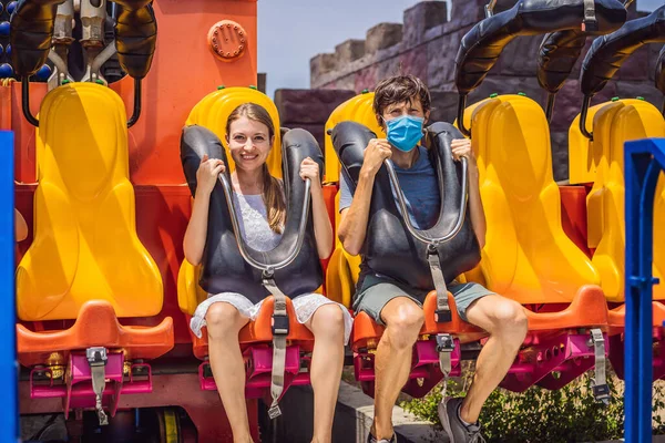 Coronovirüs salgınından sonraki yaz gününde, bir lunaparkta maske takan mutlu arkadaşlar. — Stok fotoğraf