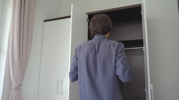 Ο νεαρός βάζει όλες τις ηλεκτρονικές συσκευές του σε μια ντουλάπα. Ψηφιακή έννοια αποτοξίνωσης — Αρχείο Βίντεο