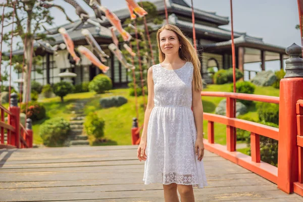 Der Reisende blieb auf der Straße stehen und betrachtete das traditionelle japanische Gebäude. Japanische Reisetouristin im Urlaub in Kyoto beim Einkaufen in einer Gasse. Besuch in Japan — Stockfoto