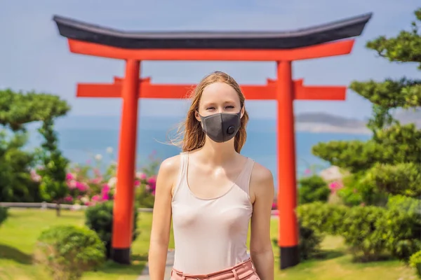 Viajero en máscara médica se detuvo en la calle y mirando el edificio tradicional japonés. Turistas viajan a Japón después de la epidemia de coronavirus — Foto de Stock