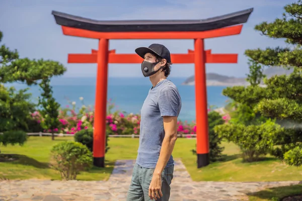 Viajante em máscara médica parou na rua e olhando para o edifício tradicional japonês. Turistas viajam no Japão após a epidemia de coronavírus — Fotografia de Stock