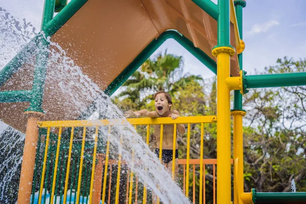 Çocuk güneşli bir günde su parkında suyla oynuyor. — Stok fotoğraf