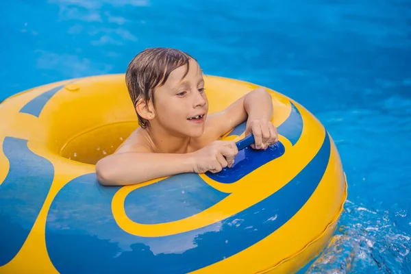 Menino em uma piscina flutuar em ondas artificiais em um parque aquático — Fotografia de Stock