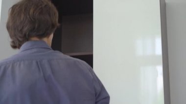 Genç adam bütün elektronik aletlerini dolaba koyuyor. Dijital detoks kavramı