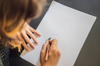 Mokup, Sahne Tasarımcısı Genç Kadın beyaz kağıda cümleler yazıyor. Süslü harfleri kazıyarak. Kaligrafi, grafik tasarım, harf, el yazısı, yaratım konsepti