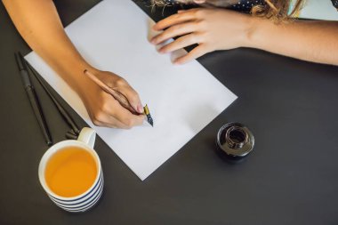 Mokup, Sahne Tasarımcısı Genç Kadın beyaz kağıda cümleler yazıyor. Süslü harfleri kazıyarak. Kaligrafi, grafik tasarım, harf, el yazısı, yaratım konsepti