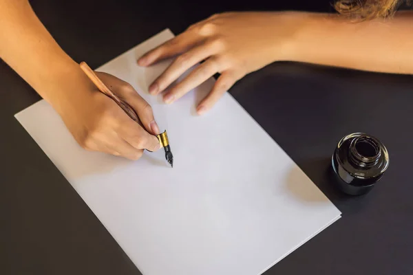 МОККУП, Сценарист-каллиграф "Молодая женщина" пишет фразу на белой бумаге. Написанные декоративные буквы. Каллиграфия, графический дизайн, письмо, почерк, концепция создания — стоковое фото