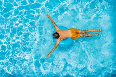 Genç adam havuzda yüzüyor, yaz tatili konsepti.