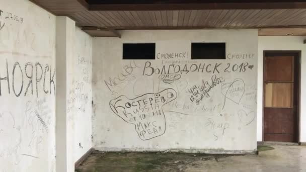 BALI, INDONESIA - 26.08.2019: Fula skrifter på ryska språket på väggarna till det så kallade övergivna hotellet på Bali. Skjuten på en telefon — Stockvideo