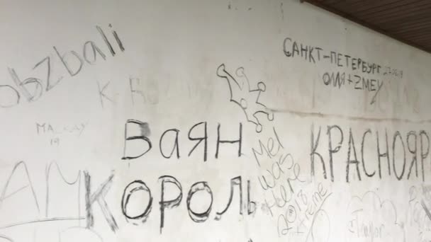 BALI, INDONESIA - 26.08.2019: Escritos feos sobre el idioma ruso en las paredes del llamado hotel abandonado en la isla de Bali. Disparo en un teléfono — Vídeo de stock