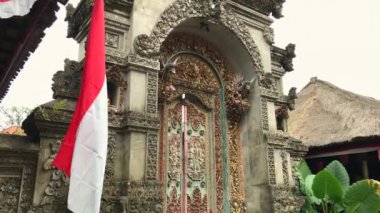Geleneksel bir Bali evine giriş. Ahşap oymalı ve taş oymalı kapı. Telefonla vurulmuş.