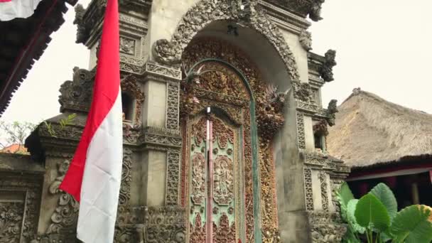 Un ingresso a una casa tradizionale balinese. Porta con intaglio in legno e scultura in pietra. Girato su un telefono — Video Stock