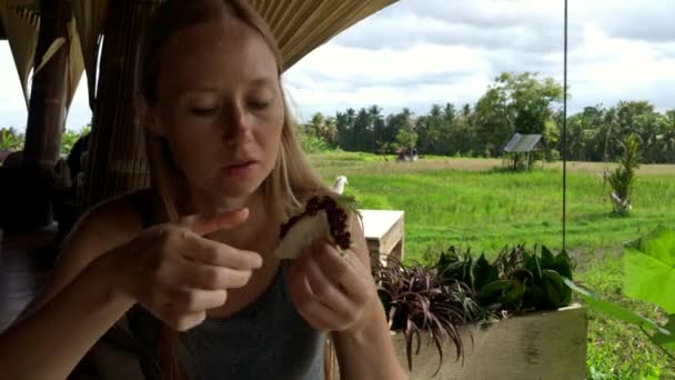 Rodina má vynikající jídlo v kavárně s výhledem na zelené rýžové pole. Cestování na Bali. Zastřelen na telefonu — Stock video